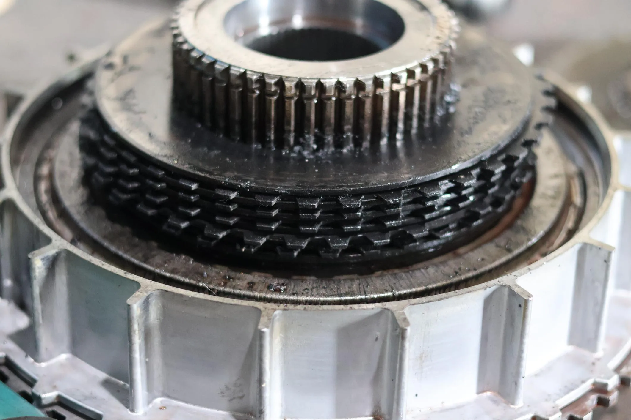 Close up of damaged automatic transmission clutch pack with burnt friction discs and bent steel plates